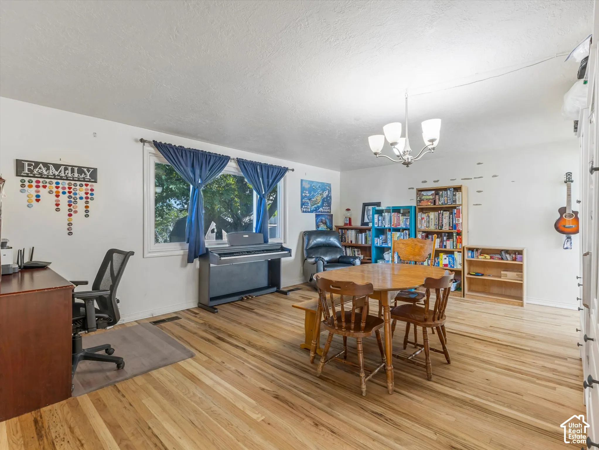 Interior space featuring wood-finish flooring, a multi-arm chandelier, and a large window