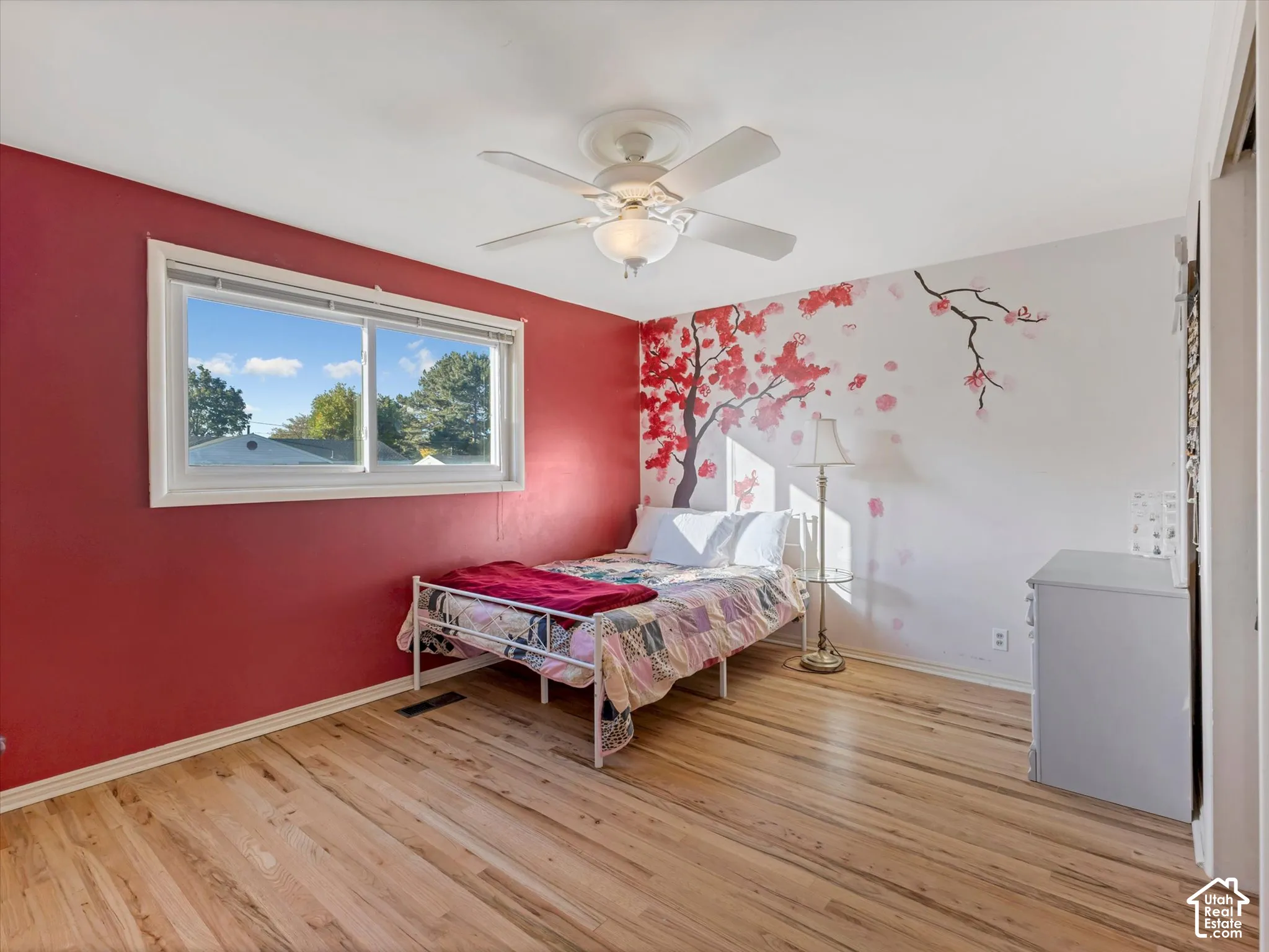 Wood-finish flooring, white ceiling fan with integrated lighting, and a window with white trim