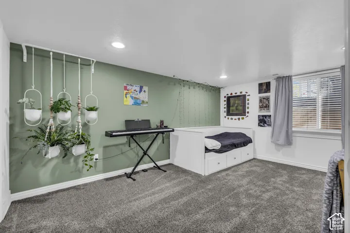 Room featuring recessed lighting, wall-to-wall carpeting, and a large window with blind treatments