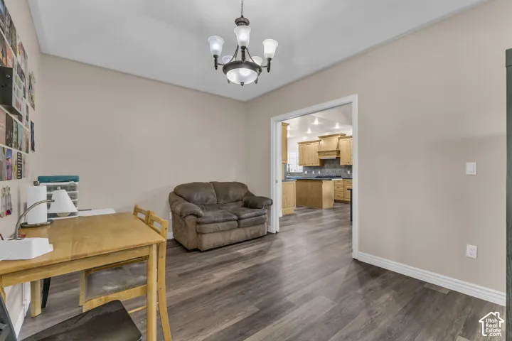 Multi-tone wood-finish flooring, five-light iron chandelier, and wide doorway casing