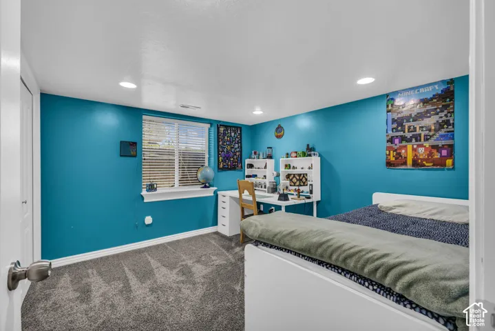 Room featuring wall-to-wall carpeting, recessed ceiling lighting, and a window with horizontal blinds