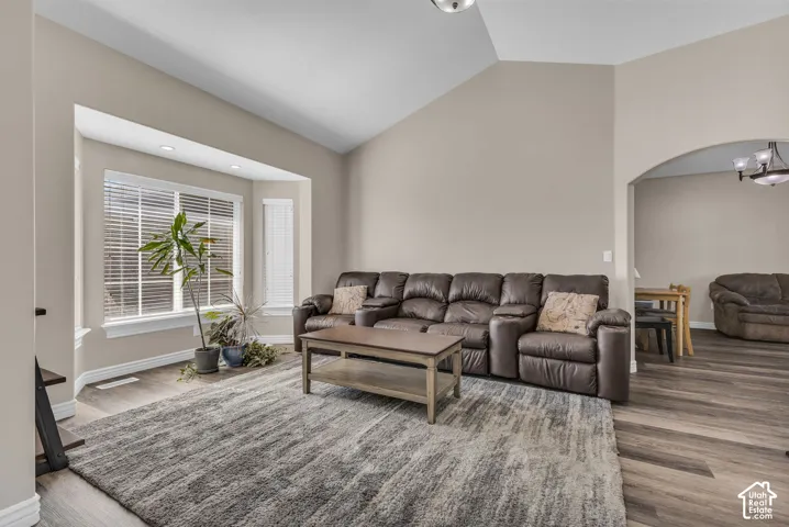 Vaulted ceilings, expansive bay window, and wood-finish flooring throughout