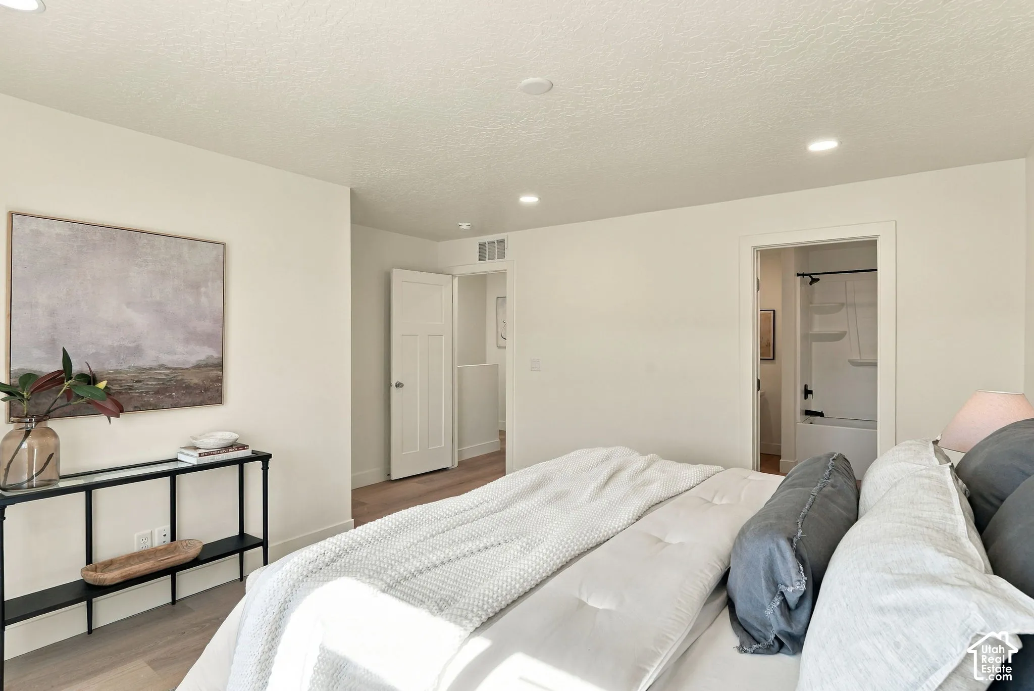 Neutral interior featuring wood-finish flooring, recessed lighting, and a multi-panel interior door