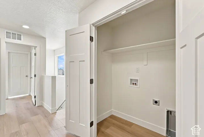 Laundry alcove featuring a built-in shelving unit, wood-finish flooring, recessed ceiling lighting, and shaker-style interior doors