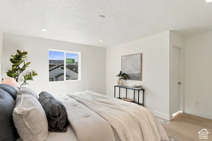 Interior room featuring light wood-finish flooring, recessed lighting, and a single-hung window with a neutral palette