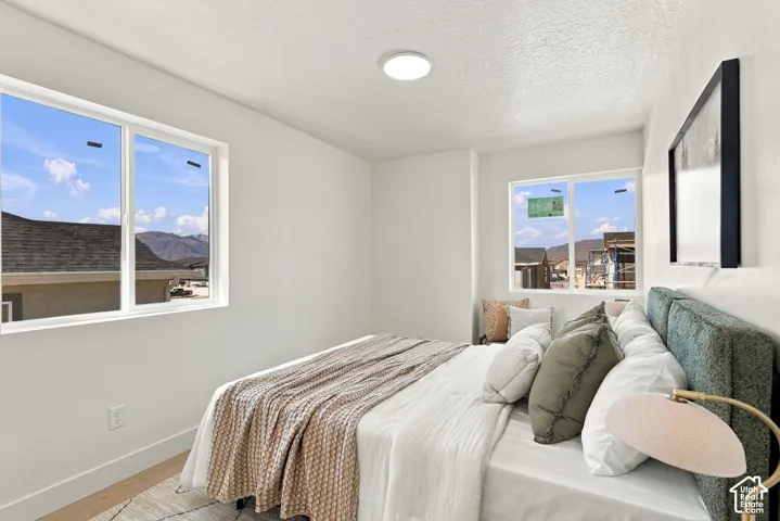 Neutral interior featuring dual-pane sliding windows, textured ceiling, flush-mount LED lighting, and light-toned flooring