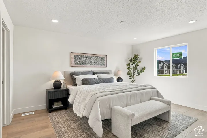 Bedroom featuring wood-finish flooring, recessed lighting, and a window with mountain scenery