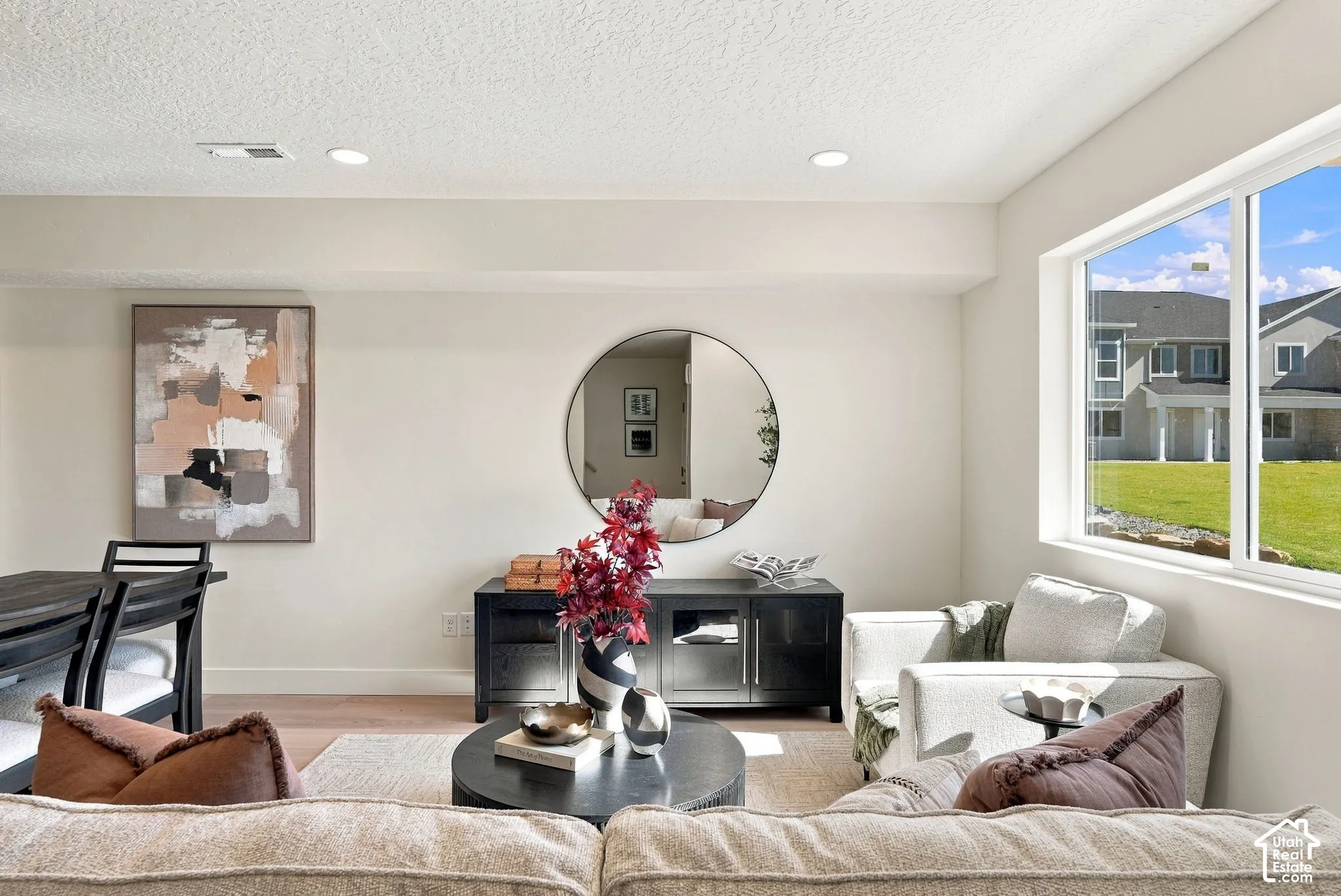 Neutral-toned interior space featuring recessed ceiling lighting, wood-finish flooring, and a large horizontal window with exterior exposure