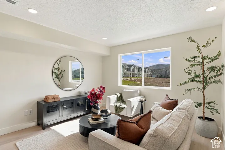 Neutral-toned interior featuring recessed lighting, large dual-pane sliding window, and wood-finish flooring
