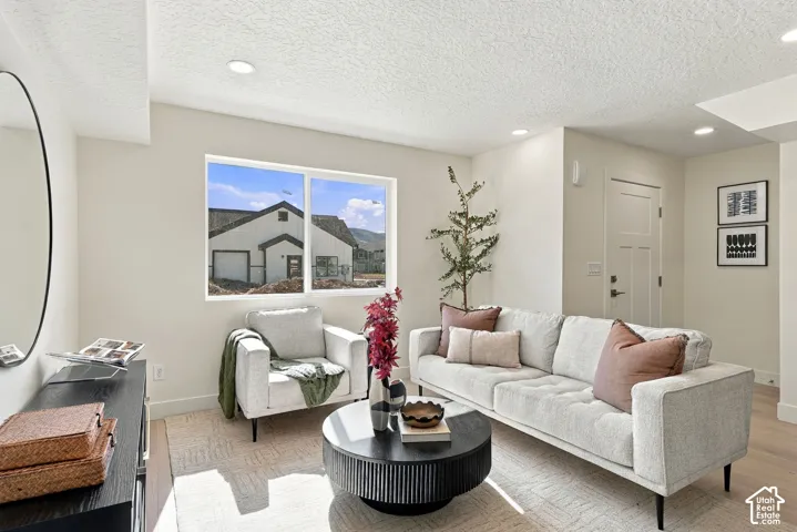 Neutral wall palette with recessed lighting, wood-finish flooring, and natural light provided by a picture window
