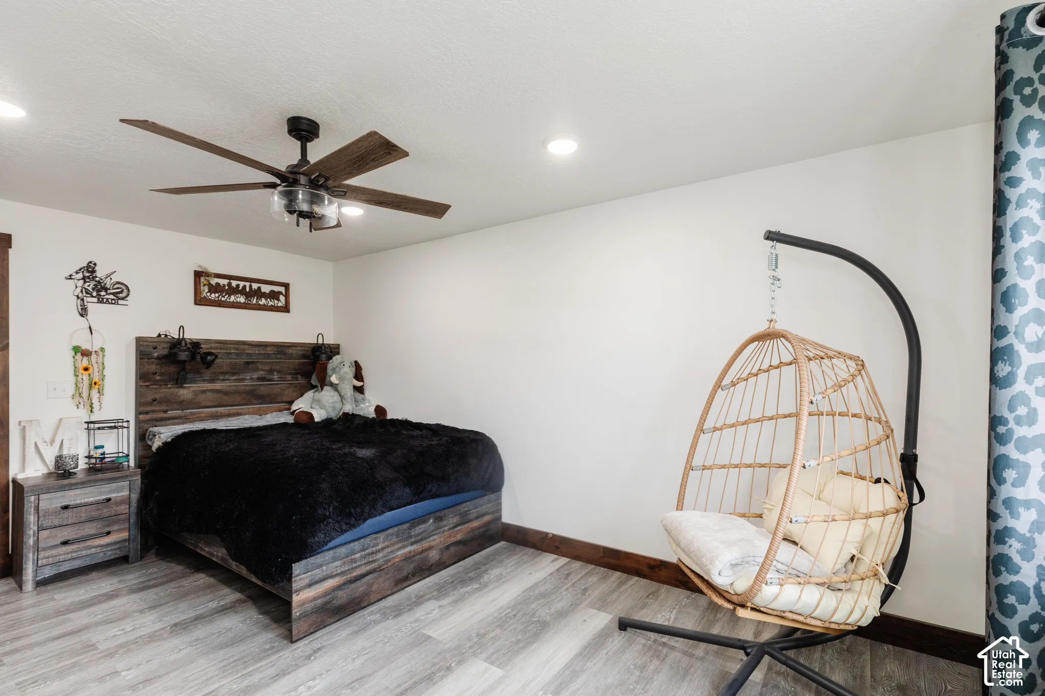 Room featuring wood-finish flooring, recessed lighting, and a multi-blade ceiling fan with integrated lighting