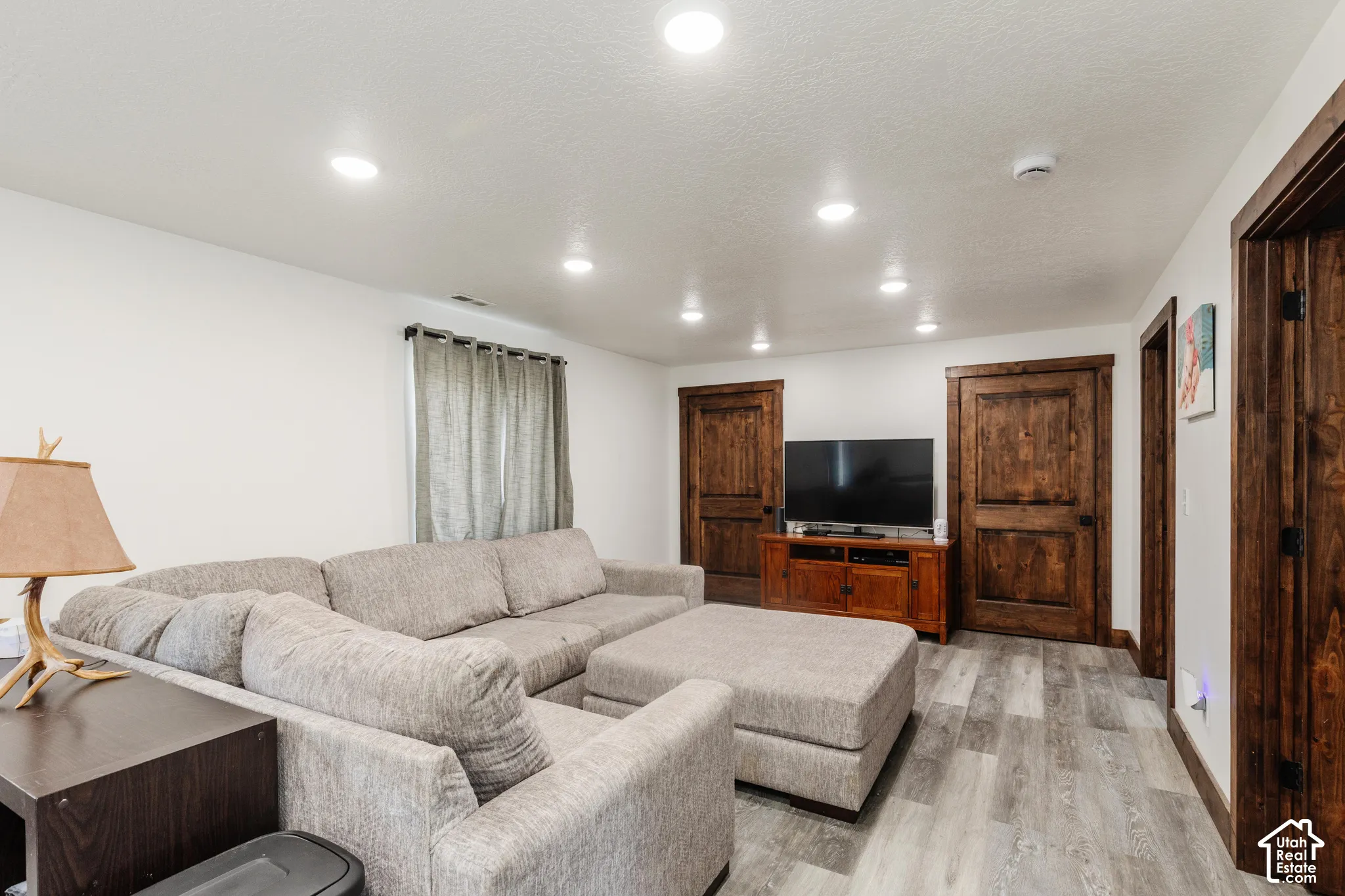 Recessed ceiling lighting, wood-finish plank flooring, and solid wood interior doors featuring dark stained finishes and matching casing