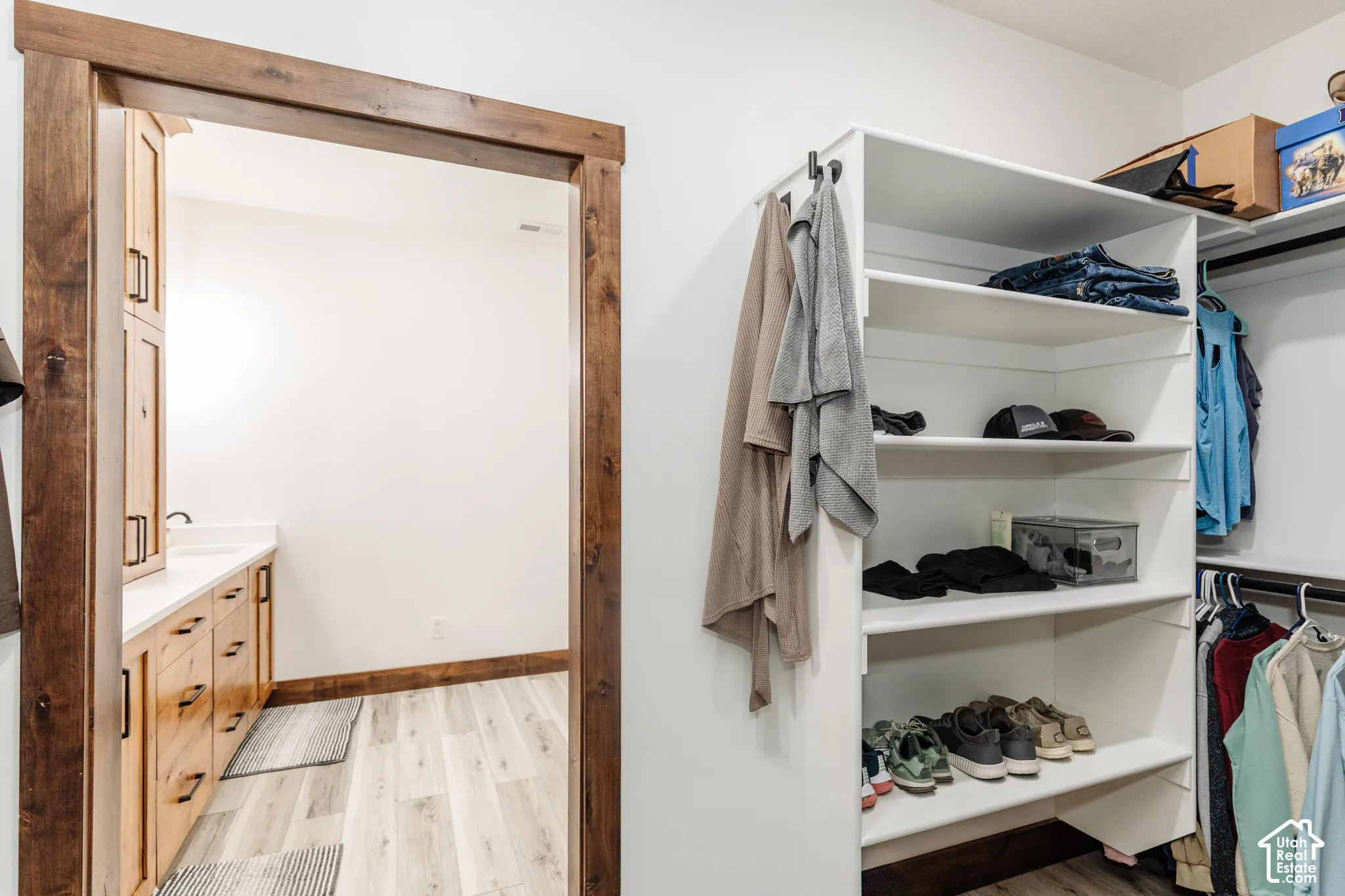 Custom white built-in shelving, natural wood-finish door casing, and wood-finish flooring