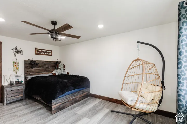 Room featuring wood-finish flooring, recessed lighting, and a multi-blade ceiling fan with integrated lighting