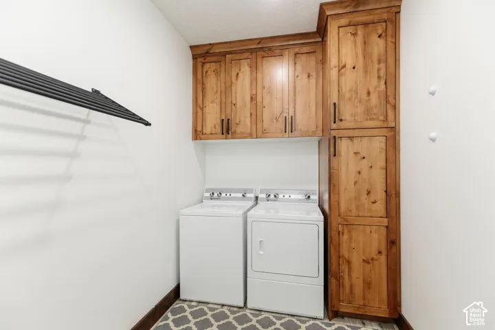 Custom wood cabinetry, floor-to-ceiling storage pantry, and mounted black metal drying rack