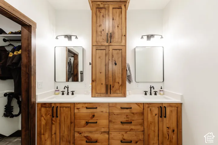 Custom wood cabinetry with central tower storage, dual undermount sinks, quartz countertop, and matte black fixtures