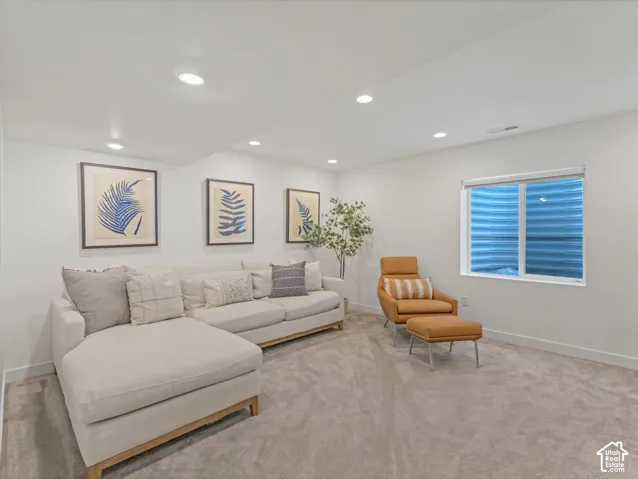 Neutral-toned carpeting, recessed ceiling lighting, and a corrugated metal window well insert