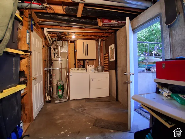 Utility area featuring a concrete floor, built-in cabinetry, an integrated water heater, and a washer and dryer set