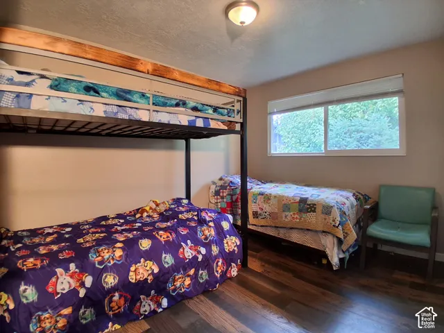 Room featuring wood-finish flooring, a ceiling-mounted light fixture, and a sliding window