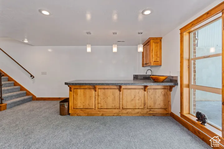 Wet bar featuring wood cabinetry,