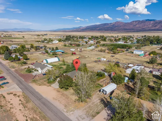 Aerial perspective of a property featuring mature trees and mountain backdrops
