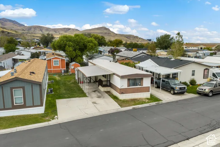 Single-level residence featuring a covered carport, concrete driveway, and mountain scenery