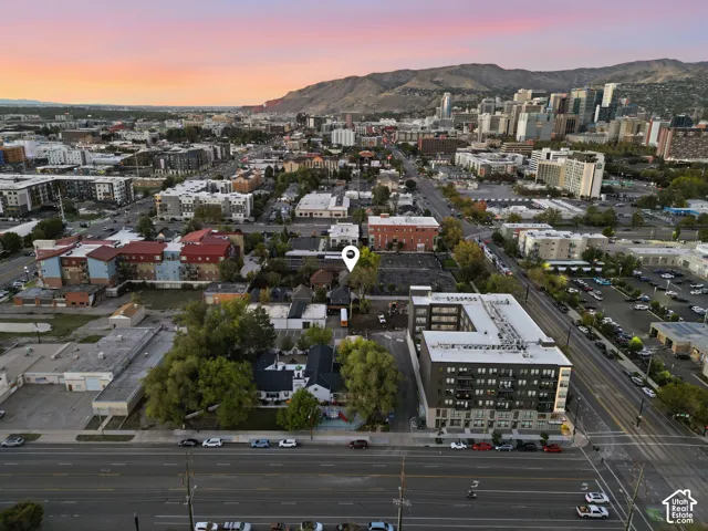 Aerial perspective featuring a central property location, urban cityscape, and a mountain backdrop