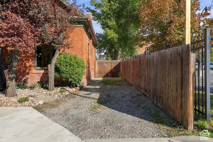 Red brick exterior with gravel grounds, wood fencing, and metal perimeter security screening