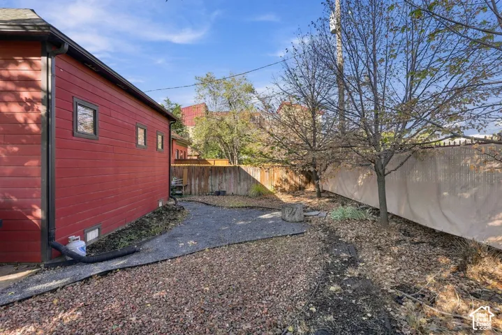 Exterior featuring horizontal siding, a gravel ground cover, and a perimeter privacy fence