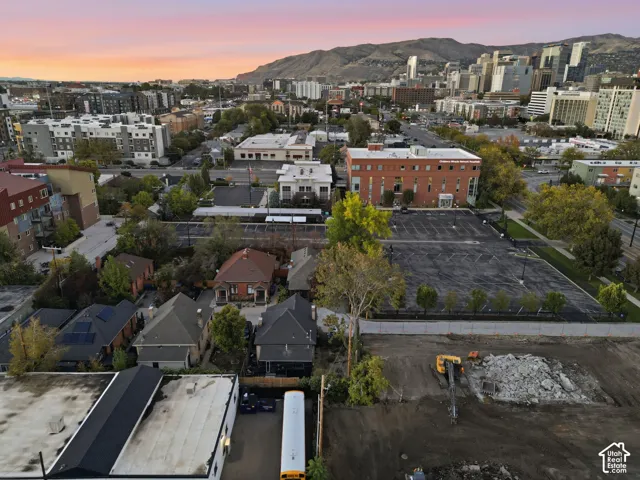 Aerial perspective featuring urban surroundings, proximity to a city skyline, and a mountain backdrop