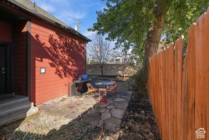 Flagstone patio featuring a wood-style horizontal siding exterior, gravel landscaping, and a privacy fence