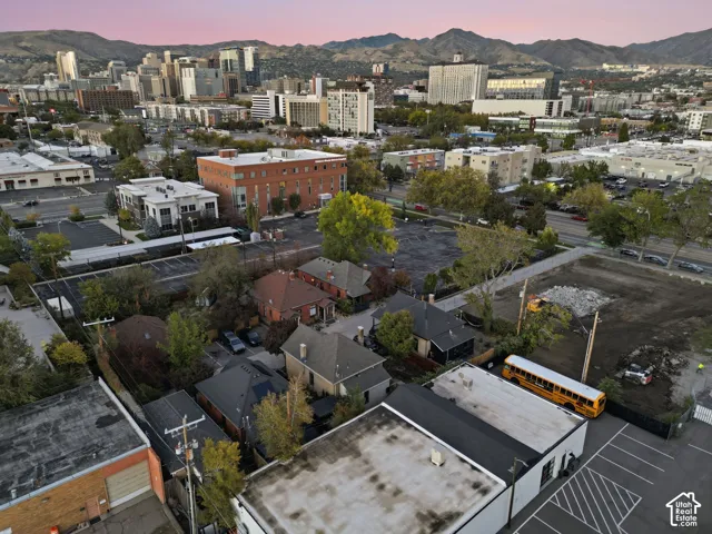 Aerial perspective of a multi-structure parcel featuring pitched shingle roofing and mountain backdrop