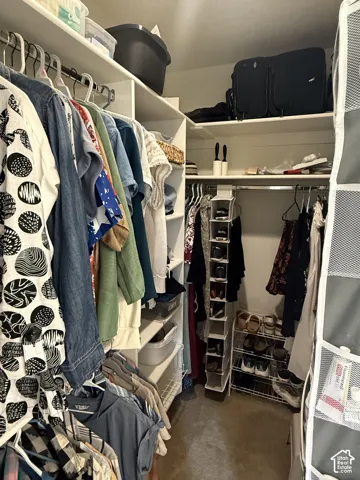 Custom reach-in closet featuring white laminate shelving, tiered vertical organization, and multi-level hanging rods