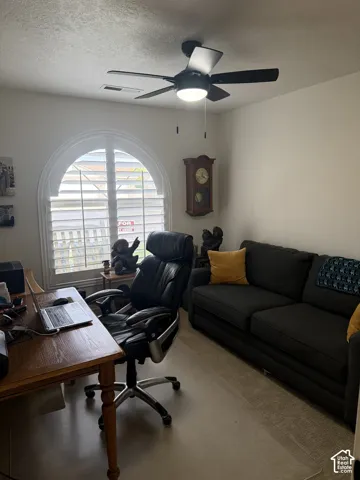 Arched window featuring white plantation shutters and a ceiling-mounted light fixture with a central fan