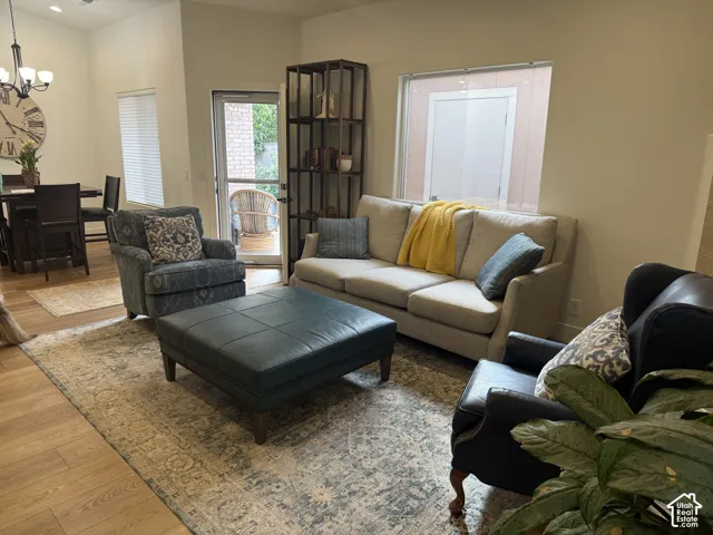 Open-concept living space featuring wood-finish flooring, vaulted ceilings, and a glass-paneled exterior door