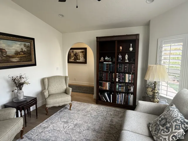 Arched pass-through, built-in dark wood shelving unit, and plantation shutters