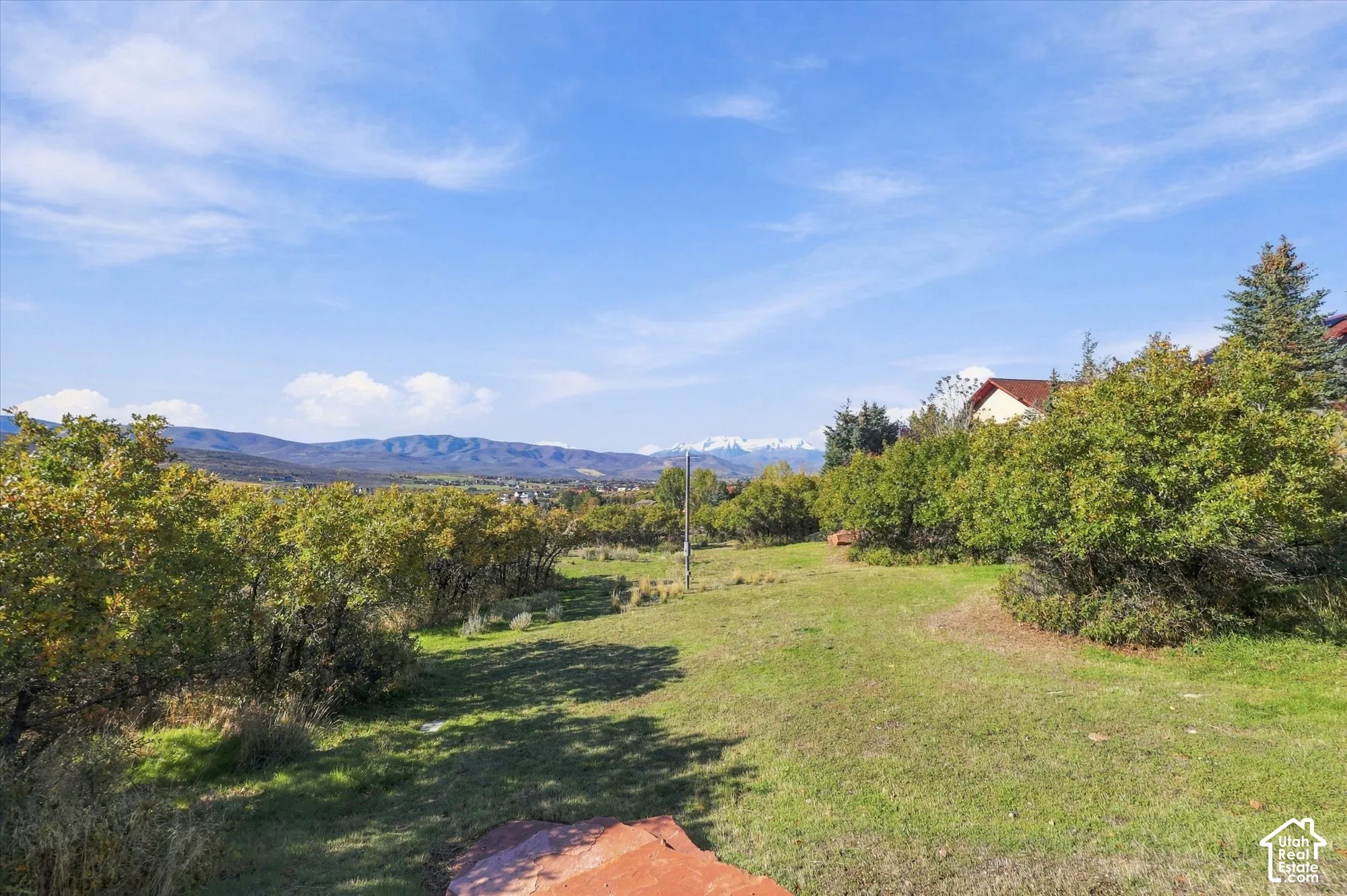 Expansive grounds featuring mature trees, native landscaping, and mountain scenery