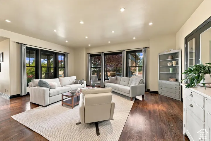 Living area featuring wood-finish flooring, recessed lighting, and large windows with dark-finish frames