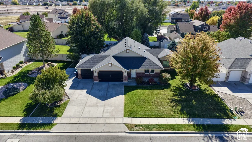 Single-level residence featuring a multi-gabled asphalt shingle roof, masonry and horizontal siding exterior, attached three-car garage, concrete driveway, and manicured landscaping