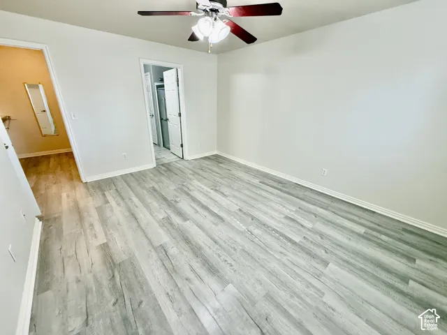Interior room featuring wood-finish flooring, a ceiling fan with integrated lighting, and neutral wall tones