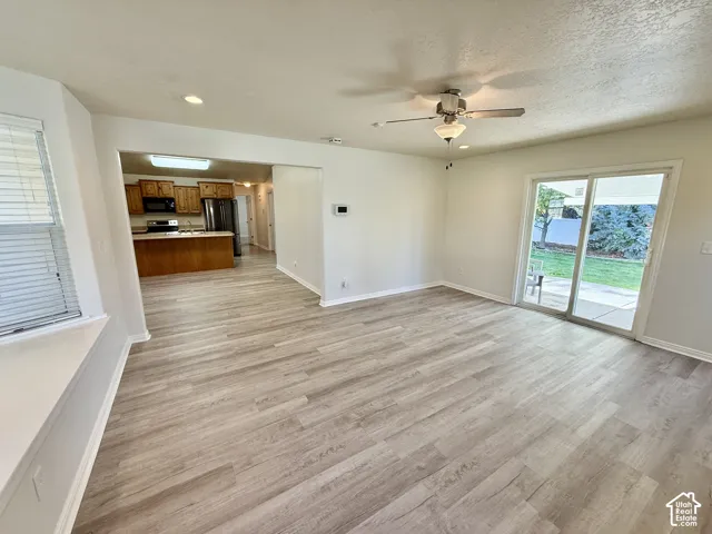 Wood-finish flooring, ceiling fan, sliding glass door, and built-in window seat
