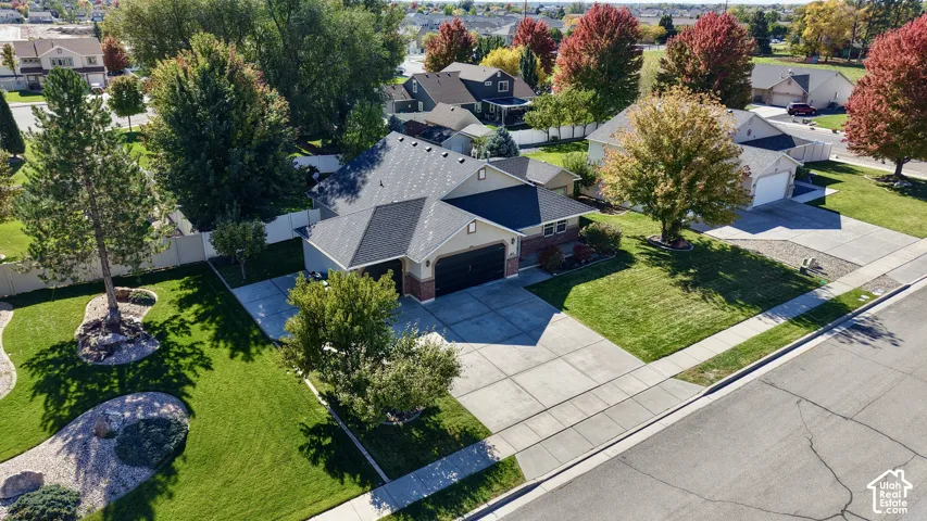 Multi-level residence featuring a brick and siding exterior, an asphalt shingle roof, an attached two-car garage, a concrete driveway, and established landscaping