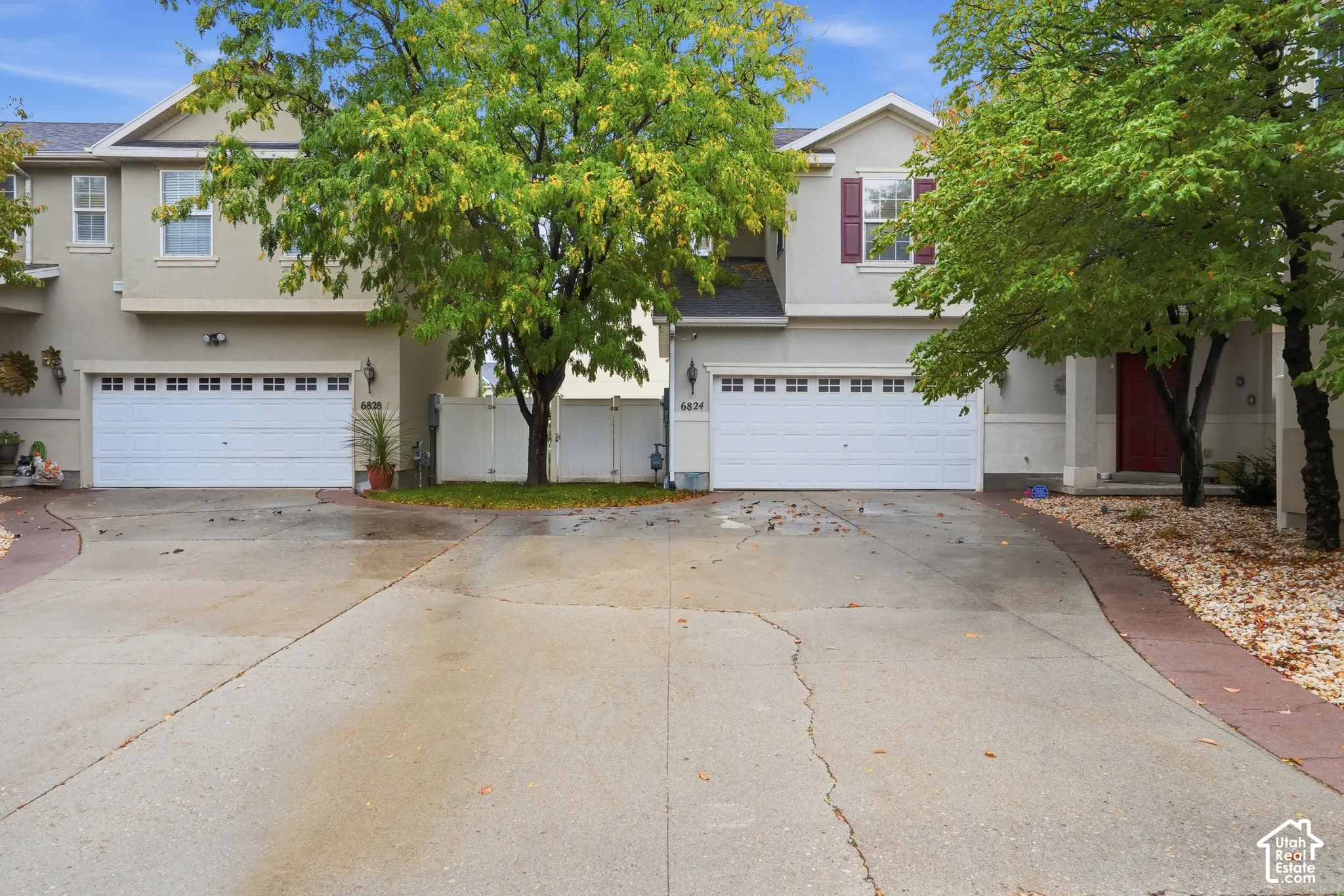 Two-story stucco exterior featuring double-car garages, multi-gabled rooflines, and decorative shutter accents