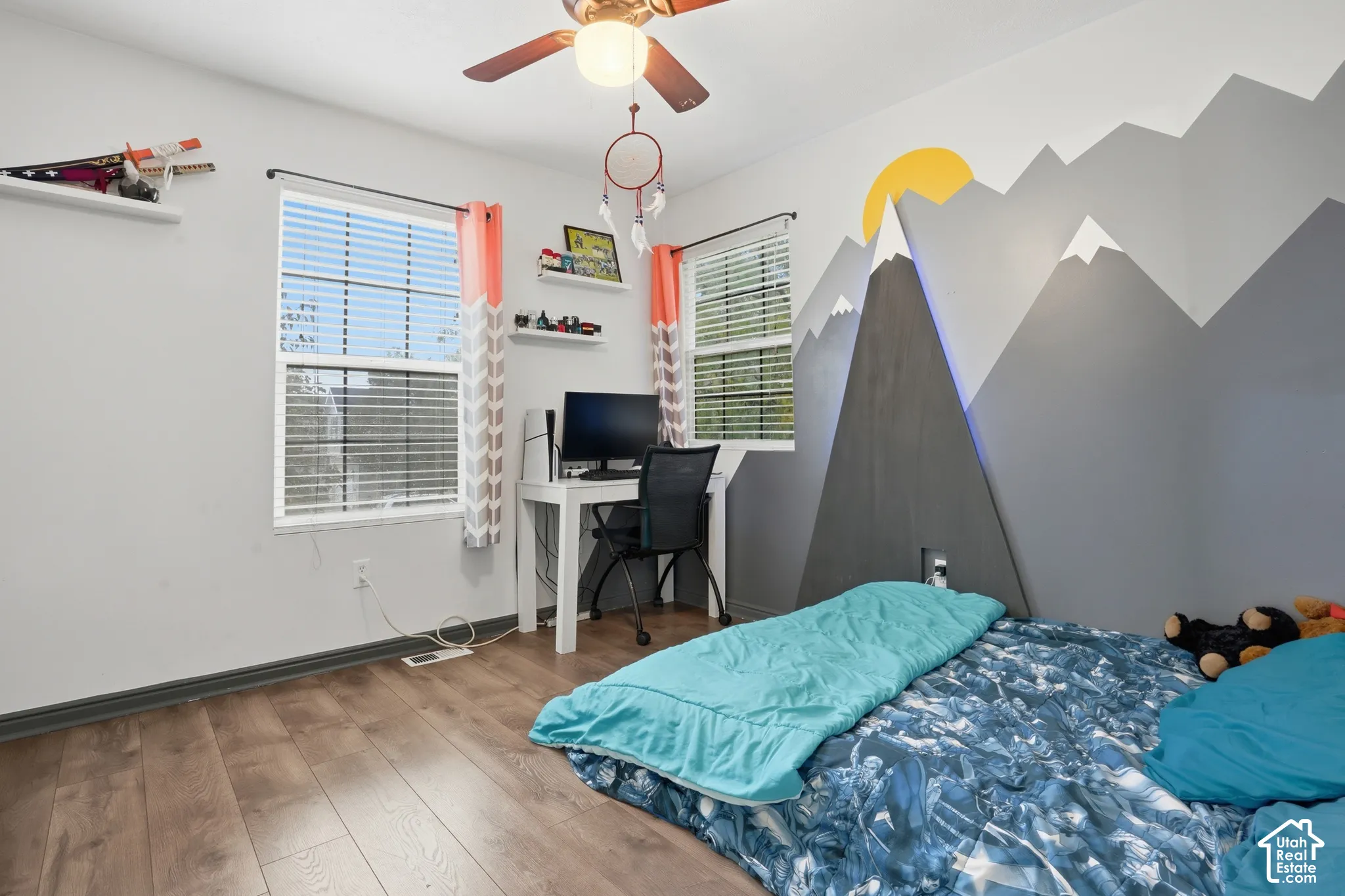 Wood-finish flooring, dual windows with blinds, ceiling fan with integrated lighting, and decorative wall mural