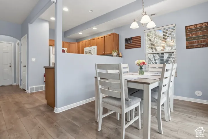Kitchen featuring wood-finish cabinetry, recessed lighting, wood-finish flooring, and a multi-light chandelier