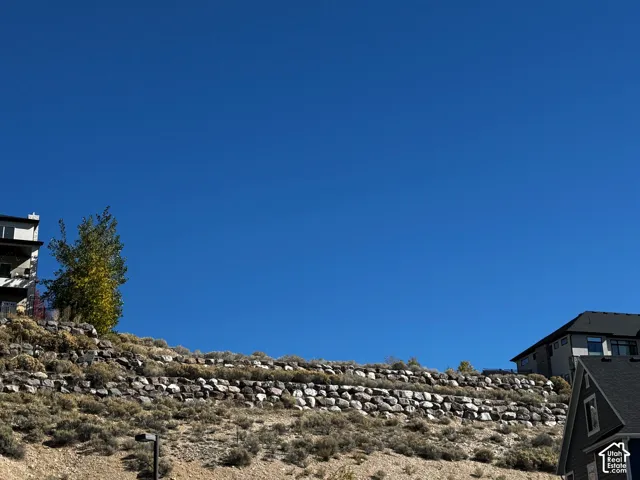 Multi-level residential properties situated on tiered terrain with stone retaining walls and native landscaping