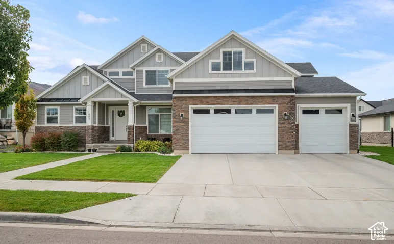 Multi-level exterior featuring vertical board-and-batten siding, stone veneer accents, multi-gable roofline, and an attached three-car garage