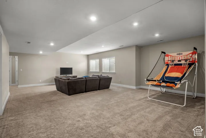 Finished interior space featuring neutral wall tones, recessed lighting, wall-to-wall carpeting, and multiple egress windows