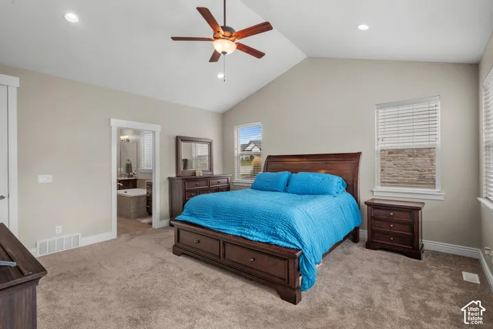 Vaulted ceilings, neutral wall tones, carpeted flooring, recessed lighting, and a ceiling fan with integrated light fixture