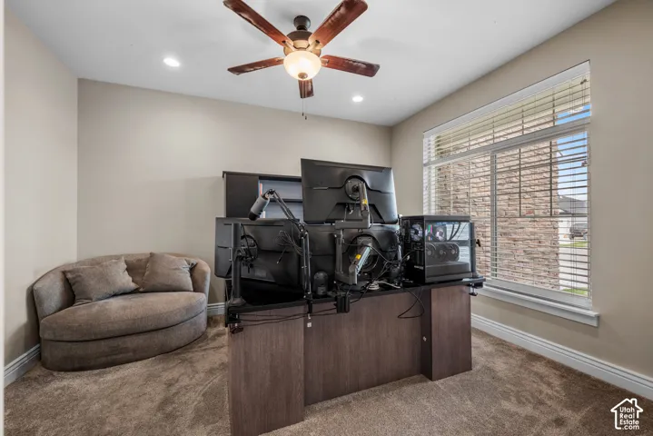 Room featuring neutral wall paint, carpeted flooring, a ceiling fan with integrated lighting, and a window with horizontal blinds